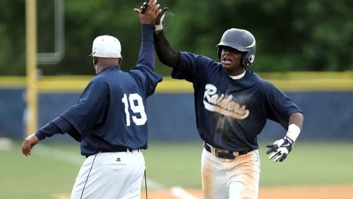 Redan's Miles Fore, right, celebrates his two-run home run with coach Marvin Pruitt in the 7th inning of the first game in the Class AAAA state final series in June, 2020, in Atlanta. (Jason Getz / AJC)