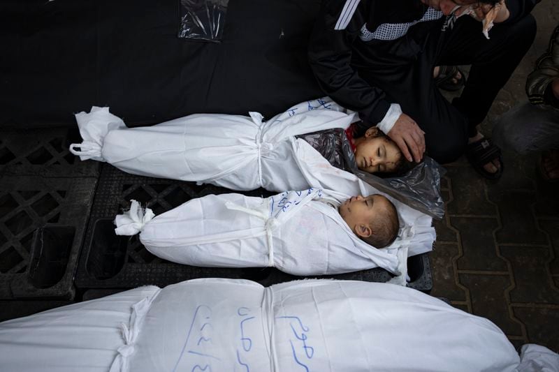 Ashraf Abu Draz mourns over the bodies of his two daughters who were killed in the Israeli bombardment of the Gaza Strip, at a hospital morgue in Rafah, southern Gaza Strip, Thursday, April 4, 2024. (AP Photo/Fatima Shbair)