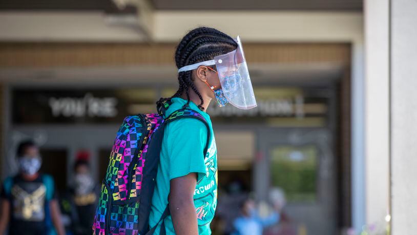 A Clarkdale Elementary School student in Cobb County wears a face shield and a face mask while at school in Austell in October 2020. Overall, 14 metro Atlanta school districts have recorded nearly 79,000 cases so far in the 2021-2022 school year.  (Alyssa Pointer / AJC file photo)