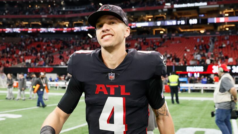 Visibly happy Falcons quarterback Desmond Ridder (4) walks off the field after the Falcons defeated the Buccaneers 30-17 for the last game of the season at Mercedes-Benz Stadium on Sunday, January 8, 2022.  Miguel Martinez / miguel.martinezjimenez@ajc.com