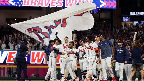 Braves players celebrate with shortstop Orlando Arcia after he hit a walk-off single. The Braves defeated San Diego Padres, 7-6.,Miguel Martinez /miguel.martinezjimenez@ajc.com