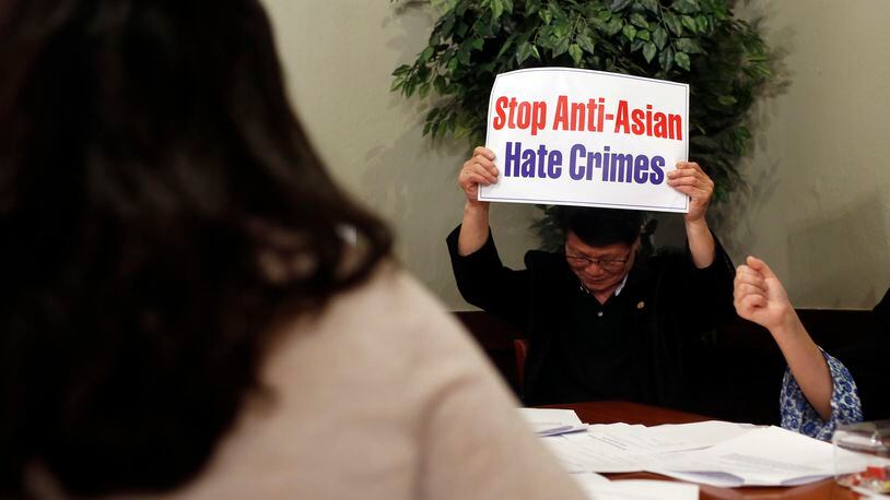 Asong Kim holds up a sign at a press conference at Chung Dam Korean Restaurant in Duluth, Georgia, on Thursday, March 18, 2021. Korean American leaders gathered to make a statement following the attacks against Asian American spas in the Atlanta area that left eight dead. (Rebecca Wright for the Atlanta Journal-Constitution)