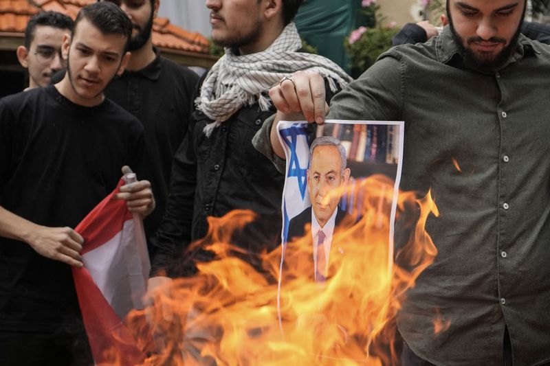 Students from the Lebanese American University (LAU) burn a picture of Israeli Prime Minister Benjamin Netanyahu during a protest inside their university campus to demand a ceasefire and show support for Palestinians in the Gaza Strip, in Beirut, Lebanon, Tuesday, April 30, 2024. Scores of students held pro-Palestinian protests at some of the largest universities in Beirut Tuesday expressing anger over the rising deaths during the Israel-Hamas war. (AP Photo/Hassan Ammar)