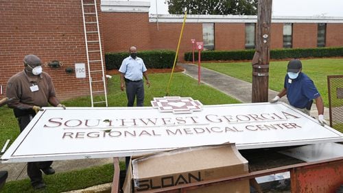 Hospital maintenance staff Jerry Daniels (left) and Jimmie Fair Sr.(right) remove the main sign as Bruce Green assists outside the Southwest Georgia Regional Medical Center as the hospital closed on Thursday, October 2, 2020. Currently, there are 18 out of 30 rural hospitals are at risk of closure, according to a recent report by Chartis. (Hyosub Shin / Hyosub.Shin@ajc.com)