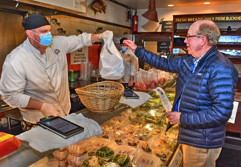 Ian Bailey, Retail Manager at Atlanta Fish Market on Pharr Road in Buckhead sells food to a walk-in customer from their market area on Thursday March 5, 2020. CHRIS HUNT FOR THE ATLANTA JOURNAL-CONSTITUTION