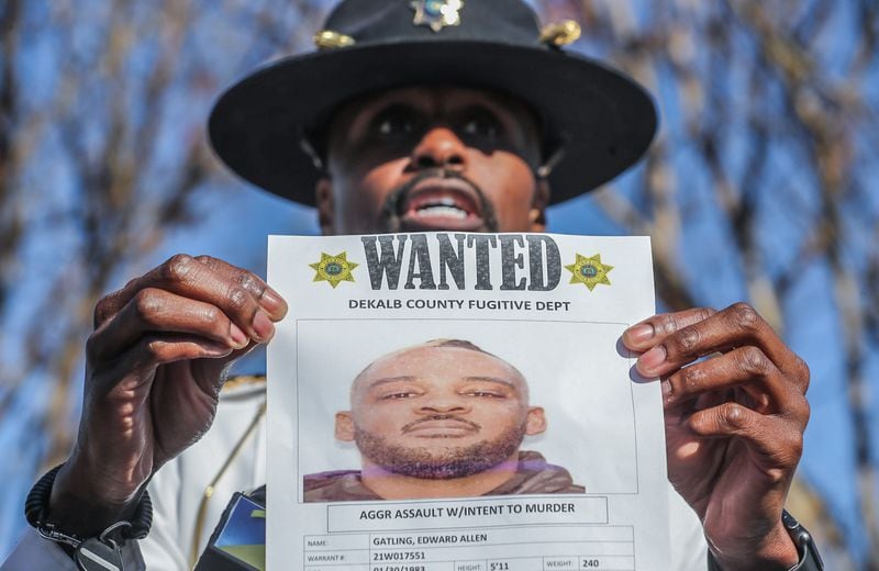 Deputy Chief Randy Akies holds a wanted poster for Edward Allen Gatling.