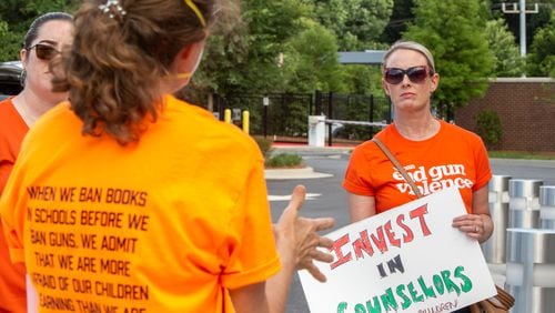 Outside the Cobb County school board's meeting, parents and advocates, including Katie Kroll, gather to voice concerns for safety at schools and accountability for finances on Thursday, June 9, 2022. (Jenni Girtman for The Atlanta Journal-Constitution)