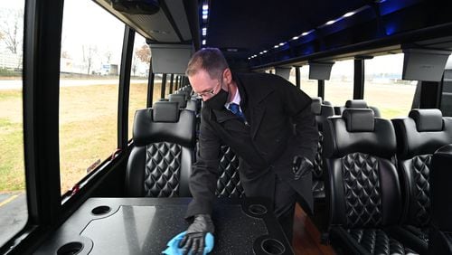 December 31, 2020 Atlanta - Eric Alimena, CEO of Alimena Limousine & Worldwide Transportation, uses a disinfectant wipe to clean a bus parked at his company on Thursday, December 31, 2020. (Hyosub Shin / Hyosub.Shin@ajc.com)