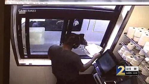 Surveillance footage appears to show a man pull up in a white Chevrolet and pass the cashier a note.