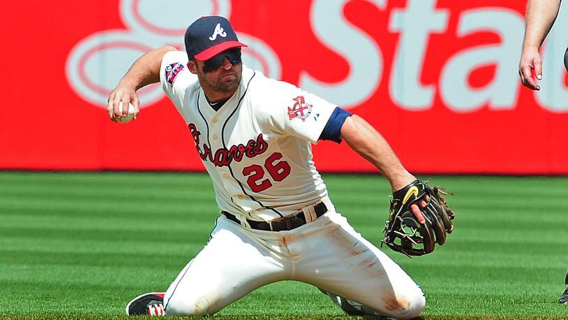 ATLANTA, GA - APRIL 27: Dan Uggla #26 of the Atlanta Braves throws out a runner from his knees during the 6th inning against the Cincinnati Reds at Turner Field on April 27, 2014 in Atlanta, Georgia. (Photo by Scott Cunningham/Getty Images) Braves second baseman Dan Uggla has had some struggles at the plate and the field. (Scott Cunningham / Getty Images)
