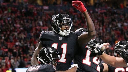 Falcons wide receiver Julio Jones celebrates his touchdown catch with Taylor Gabriel and Justin Hardy on a pass from wide receiver Mohamed Sanu during a trick play to take a 10-3 lead during the second quarter in a NFL football game on Sunday, November 26, 2017, in Atlanta. Jones caught two touchdown passes in the second quarter.   Curtis Compton/ccompton@ajc.com