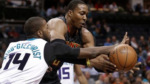Atlanta Hawks’ Dwight Howard, right, and Michael Kidd-Gilchrist, left, chase a loose ball during the first half of an NBA basketball game in Charlotte, N.C., Monday, March 20, 2017. (AP Photo/Chuck Burton)