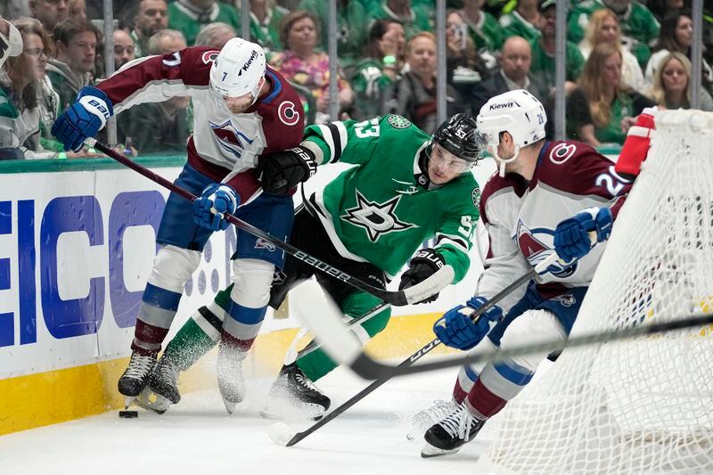 Colorado Avalanche defenseman Devon Toews (7) and defenseman Sean Walker, right, work to keep control of the puck in front of Dallas Stars center Wyatt Johnston (53) during the first period in Game 2 of an NHL hockey Stanley Cup second-round playoff series in Dallas, Thursday, May 9, 2024. (AP Photo/Tony Gutierrez)