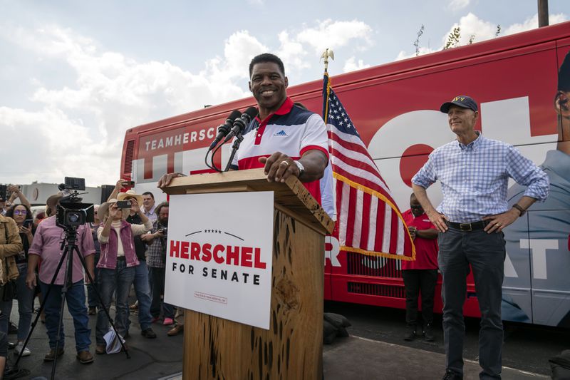 Herschel Walker, the Republican candidate for Senate, is joined onstage by U.S. Sen. Rick Scott (R-Fla.) as he speaks during a campaign rally in Carrollton, Georgia on Oct. 13, 2022. Scott is campaigning with Walker again this week. (Nicole Craine/The New York Times)