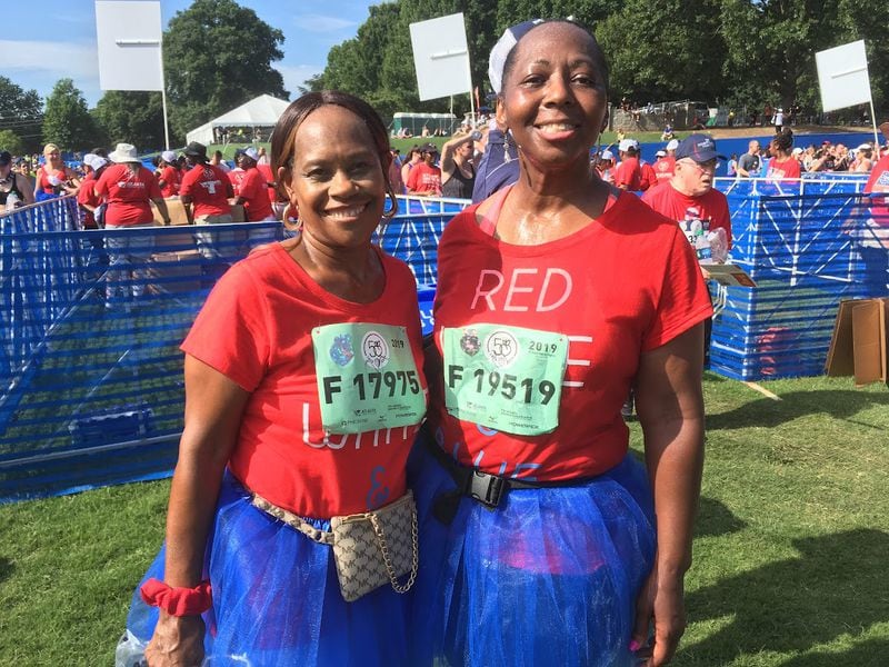 Longtime AJC Peachtree Road Race participant Linda Buckley (right) poses with friend Missouri Neely in Piedmont Park after completing the 2019 race. Buckley is such a fan of the race that, since running her first in 2000, she has brought about 15 friends with her over the years, including Neely. (AJC photo by Ken Sugiura)