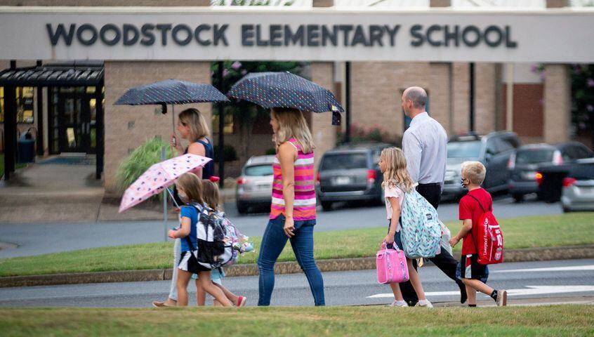 Parents walk their children to the entrance of Woodstock Elementary School on the first day of school on August 3, 2020. First Day at School Woodstock Elementary School