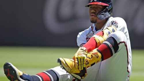 Braves outfielder Ronald Acuna grabs his left foot after falling in the seventh inning against the Toronto Blue Jays Thursday, May 13, 2021, at Truist Park in Atlanta. (Ben Margot/AP)