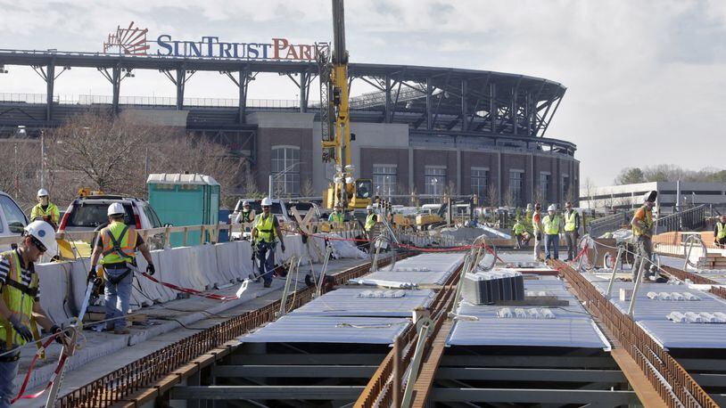 The elevated walkway over Windy Ridge Parkway to SunTrust Park is under construction and is one of the projects for which the Braves are seeking reimbursement from Cobb taxpayers. There is an on-going dispute between the county and Braves as to whether taxpayers are responsible for roads, bridges and other pedestrian improvements in and around the SunTrust Park development. BOB ANDRES /BANDRES@AJC.COM