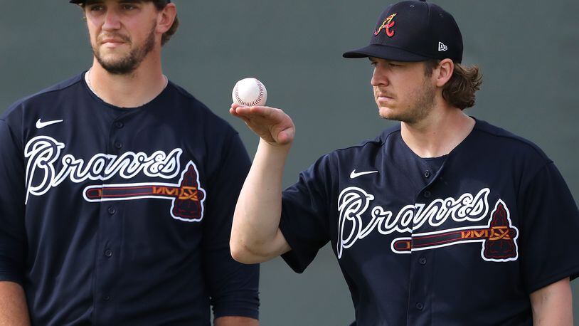 Braves pitcher Jacob Webb (right) balances a baseball while loosening up his arm with Patrick Weigel during spring training on Friday, Feb. 14, 2020, in North Port.  Curtis Compton ccompton@ajc.com