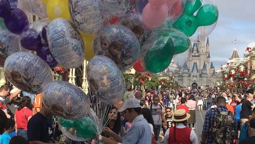 A Disney World employee sells balloons at the crowded Magic Kingdom park after Christmas. GABRIELLE RUSSON/ORLANDO SENTINEL/TNS
