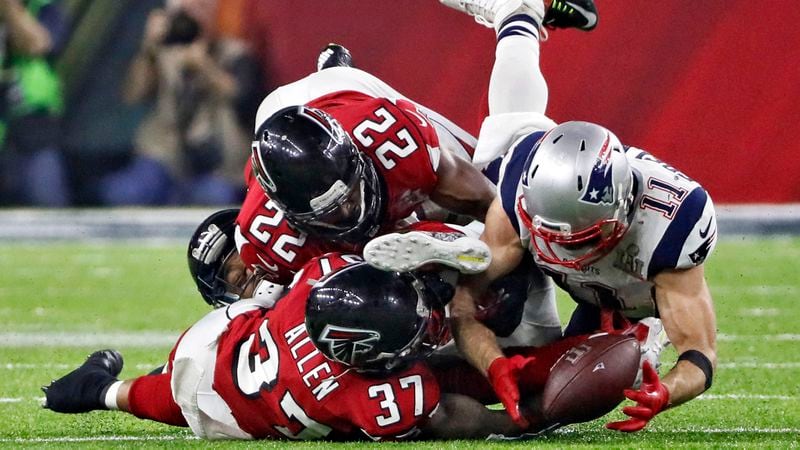 Patriots receiver Julian Edelman  concentrates on the ball as Falcons' Ricardo Allen (37) and Keanu Neal attempt to defend pivotal play in Super Bowl LI Feb. 5, 2017, at NRG Stadium in Houston.