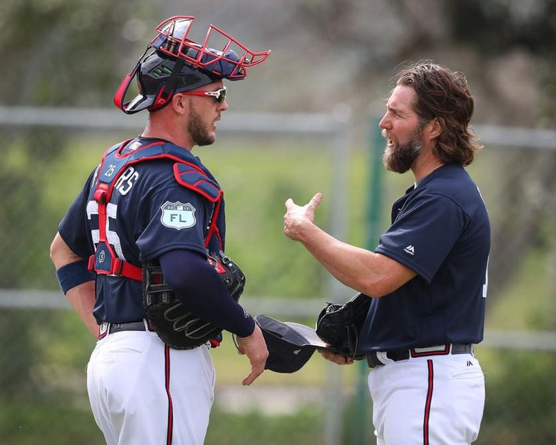  R.A. Dickey and catcher Tyler Flowers began to develop a good working relationship at spring training. Here they went over things after Dickey's first mound session at training camp. (Curtis Compton/AJC)