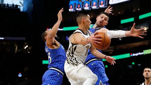 Atlanta Hawks guard Jeremy Lin (7) passes around Orlando Magic center Nikola Vucevic (9) in the first half Monday, Jan. 21, 2019, in Atlanta.