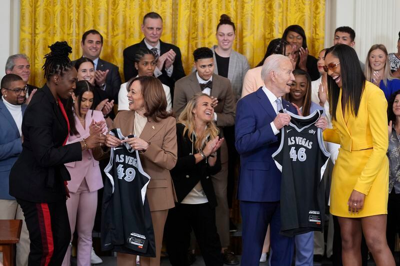 A'ja Wilson, right, and right, Chelsea Gray, left, of the WNBA's Las Vegas Aces, present jerseys to President Joe Biden, center right, and Vice President Kamala Harris, center left, during an event to celebrate the 2023 WNBA championship team, in the East Room of the White House, Thursday, May 9, 2024, in Washington. (AP Photo/Evan Vucci)