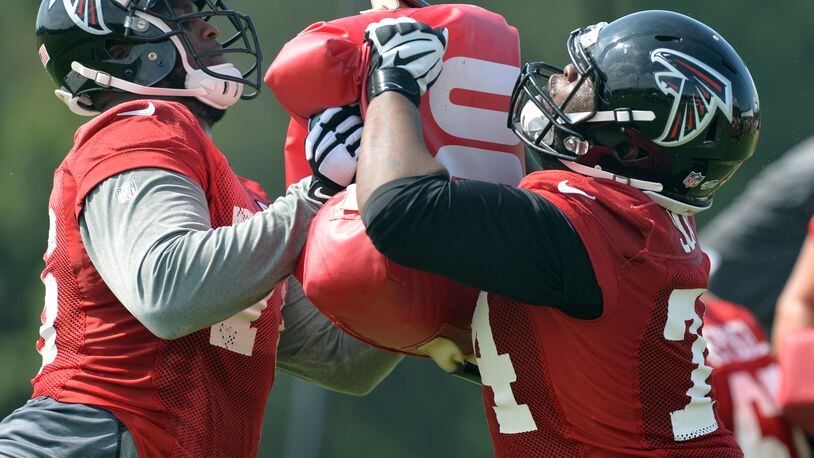 Atlanta Falcons tackles Lamar Holmes, left, and Terren Jones participate in drills during training camp on Friday, July 25, 2014.