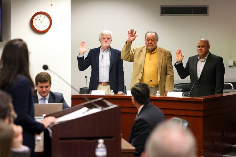 Leo Briggs, left, and cousins Marvin Smith, second from right, and Blaine Smith, right, testify in opposition to the request of the Sandersville Railroad Company to acquire several pieces of property by eminent domain in Sparta, Georgia, during the Georgia Public Service Commission hearing at the Georgia Public Service Commission building, Wednesday, Nov. 29, 2023, in Atlanta. The Smith cousins own property that the railroad company is trying to acquire. (Jason Getz / Jason.Getz@ajc.com)