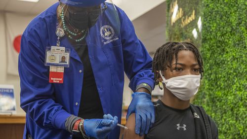 Clayton County Public Schools Nurse Supervisor Lisa Gattis administers a Pfizer COVID-19 vaccine to Isiah Osby at G.P. Babb Middle School Sept. 21, 2021. The district will administer vaccinations at middle and high schools in March and April. (Alyssa Pointer/AJC file photo)