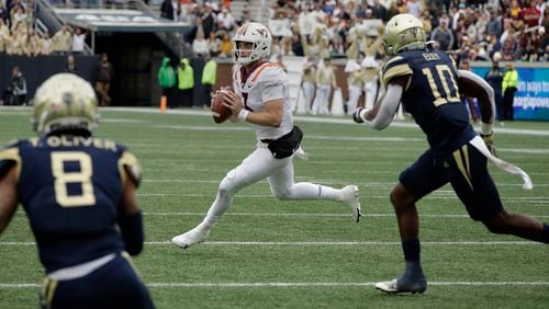 Virginia Tech quarterback Braxton Burmeister, center, looks to pass against Georgia Tech's Tobias Oliver (8) and Ayinde Eley (10) during the first half of an NCAA college football game Saturday, Oct. 30, 2021, in Atlanta. (AP Photo/Ben Margot)
