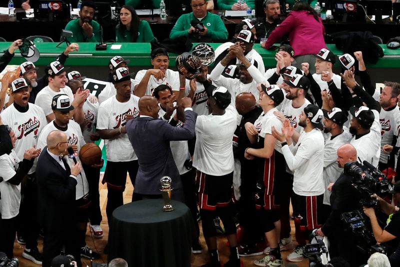 Miami Heat's Bam Adebayo, center, hoists the Bob Cousy Trophy after winning the Eastern Conference finals as teammates celebrate after the Heat defeated the Boston Celtics 103-84 in Game 7 of the NBA basketball Eastern Conference finals Monday, May 29, 2023, in Boston. (AP Photo/Michael Dwyer)