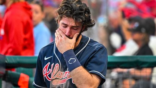 Braves shortstop Dansby Swanson is emotional in the dugout as the Phillies celebrate their 8-3 win in Game 4 of the National League Division Series on Saturday at Citizens Bank Park in Philadelphia. (Hyosub Shin / Hyosub.Shin@ajc.com)