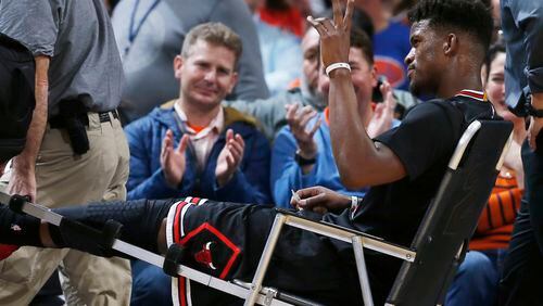 Chicago Bulls guard Jimmy Butler waves to fans as they applaud him while Butler is taken off the court after being injured late in the first half of his team's NBA basketball game against the Denver Nuggets on Friday, Feb. 5, 2016, in Denver. (AP Photo/David Zalubowski)