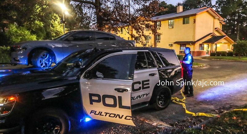 Fulton County police tow a Dodge Charger from the Super Inn on Fulton Industrial Boulevard, where a Cobb County police officer was injured in a shooting Tuesday morning.