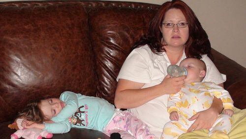 Amy Corn gives her son a bottle while her daughter lies nearby. Corn suffered from postpartum depression after both pregnancies. CONTRIBUTED