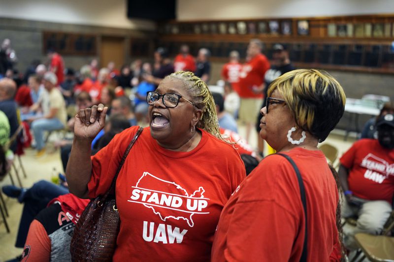 Volkswagen automobile plant employee Vicky Holloway, left, and union supporter Jackie Camper celebrate as they watch the results of a UAW union vote, late Friday, April 19, 2024, in Chattanooga, Tenn. (AP Photo/George Walker IV)