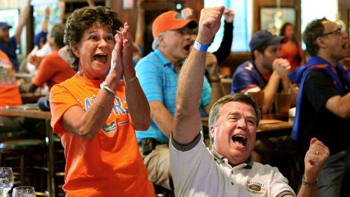 University of Florida fans Patt and Kent Lytle, of Cumming, celebrate Florida's final touchdown during their game against University of Miami (Ohio) on television at Miller Ale House Saturday afternoon in Alpharetta in this 2010 file photo.