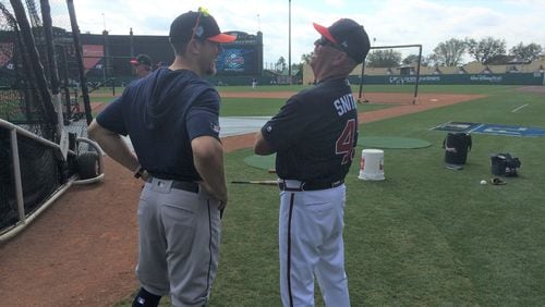 Braves manager Brian Snitker, right, has a moment with his son around the batting cage prior to Monday's spring training game at the ESPN Wide World of Sports. (Staff photo by Steve Hummer/shummer@ajc.com)