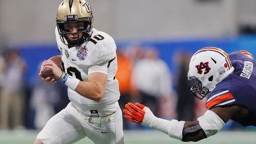 ATLANTA, GA - JANUARY 01:  McKenzie Milton #10 of the UCF Knights runs with the ball as Marlon Davidson #3 of the Auburn Tigers attempts to tackle him in the first half during the Chick-fil-A Peach Bowl at Mercedes-Benz Stadium on January 1, 2018 in Atlanta, Georgia.  (Photo by Kevin C. Cox/Getty Images)