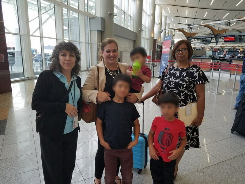 Saying airport goodbyes are three boys heading to Honduras to be reunited with their mother along with two case managers from the Hall County office of the Division of Family and Children Services. Pictured, from left to right, are Case Manager Claudia Goodwin; Angelina Williams, of the office of the Honduran consul general to Atlanta; and Case Manager Milagros Cruz. Their reunion is part of an effort by the state agency to work closer with the more than 50 consulates in Georgia. The children’s identity is obscured in the photos because Georgia law prohibits identifying children in foster care.