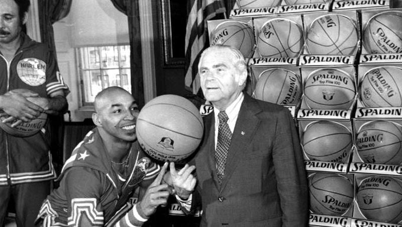 Fred “Curly” Neal shows New York City Mayor Abe Beame the art of balancing a basketball on a finger during a ceremony at City Hall. 
