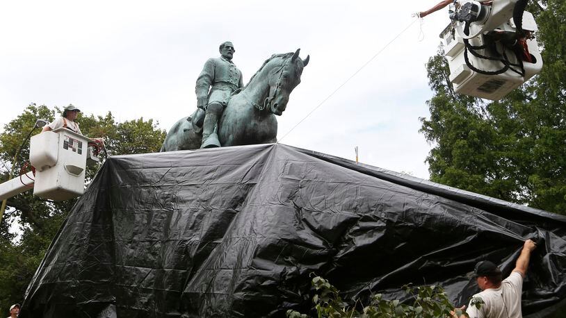 City workers drape a tarp over the statue of Confederate Gen. Robert E. Lee in Emancipation Park in Charlottesville, Va. AP file/Steve Helber