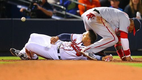 Andrelton Simmons was safe and Nationals third baseman Yunel Escobar had a cut left hand after this slide by Simmons that infuriated Washington players during Monday's 8-4 Atlanta win. (Curtis Compton/AJC)
