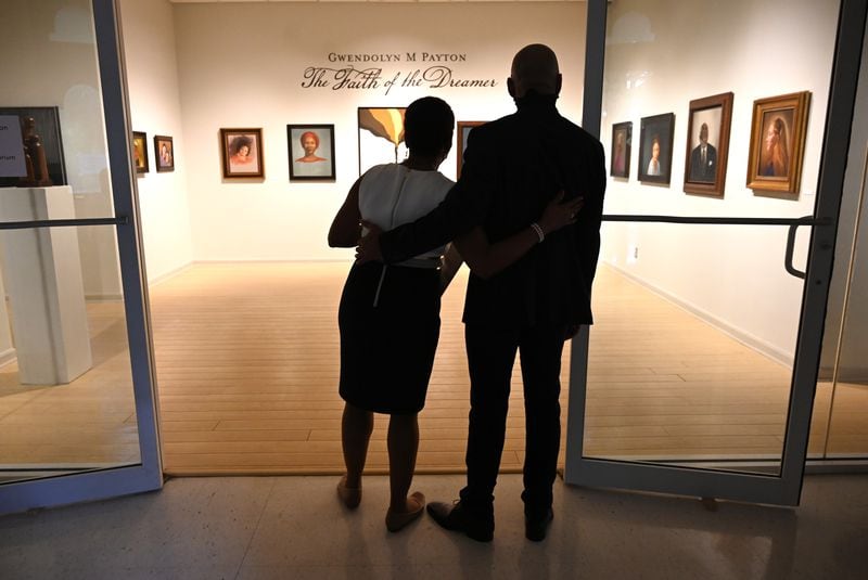 Gwendolyn Payton and her son Khary Payton, known for playing King Ezekiel on "The Walking Dead," embrace as they enter her new gallery exhibition at Plunkett Gallery in the Hardman Hall Fine Arts Building at Mercer University in Macon on Friday, Sept. 25, 2020. Hyosub Shin / Hyosub.Shin@ajc.com