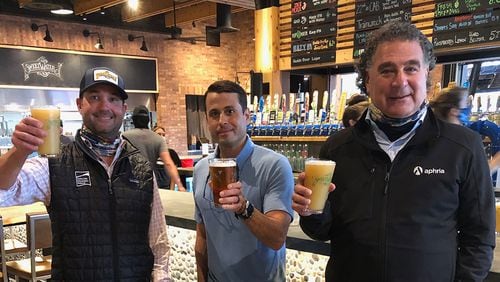 SweetWater founder and CEO Freddy Bensch (from left) and VP of Marketing Brian Miesieski are shown with Aphria CEO Irwin D. Simon in the SweetWater taproom. (Courtesy of SweetWater Brewing Co.)