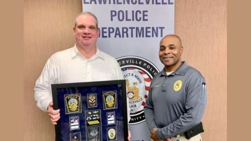 Lawrenceville Police Captain Ryan Morgan (L) seen here as the department  celebrated his retirement in late December. He's pictured with Major Myron Walker R) , the agency's assistant chief. Morgan informed the city of his decision to retire the night before he was set to be interviewed by an independent investigator looking into sexual harassment within the agency.