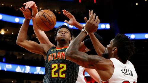 Hawks rookie Cam Reddish has the ball stripped by the Heat's Kelly Olynyk as he drives against Chris Silva Oct. 31, 2019, at State Farm Arena in Atlanta.