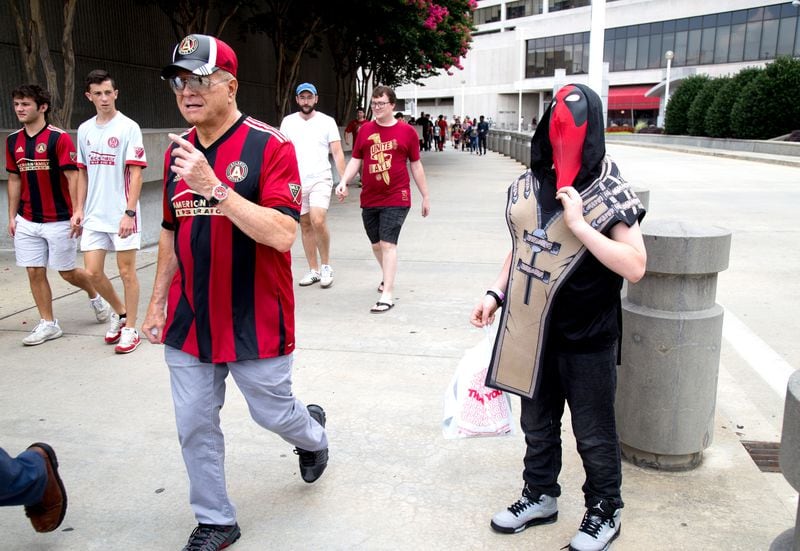 T.J. Adkisson, 13,  adjusts his Deadpool costume mask near CNN Center as Atlanta United fans head to the game at Mercedes-Benz Stadium on Sunday, July 15, 2018. (Photo: STEVE SCHAEFER / SPECIAL TO THE AJC)